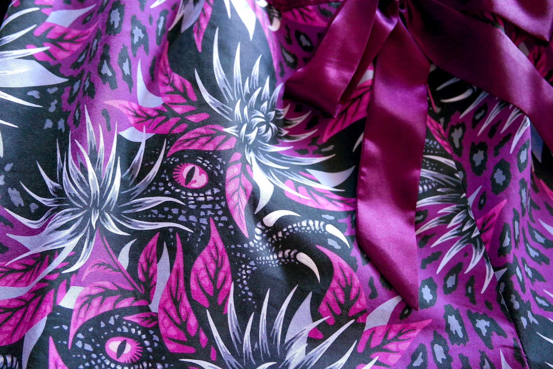 Fabric with dinosaurs and flowers purple by Andrea Muller